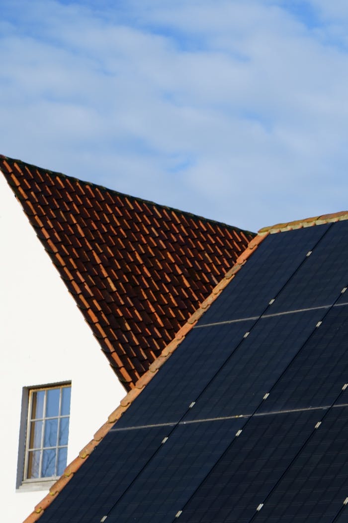 Close-up of solar panels and a tiled roof, showcasing renewable energy solutions in architecture.