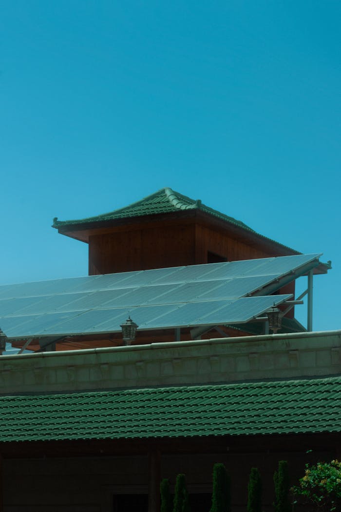A traditional pagoda with modern solar panels under a clear blue sky.